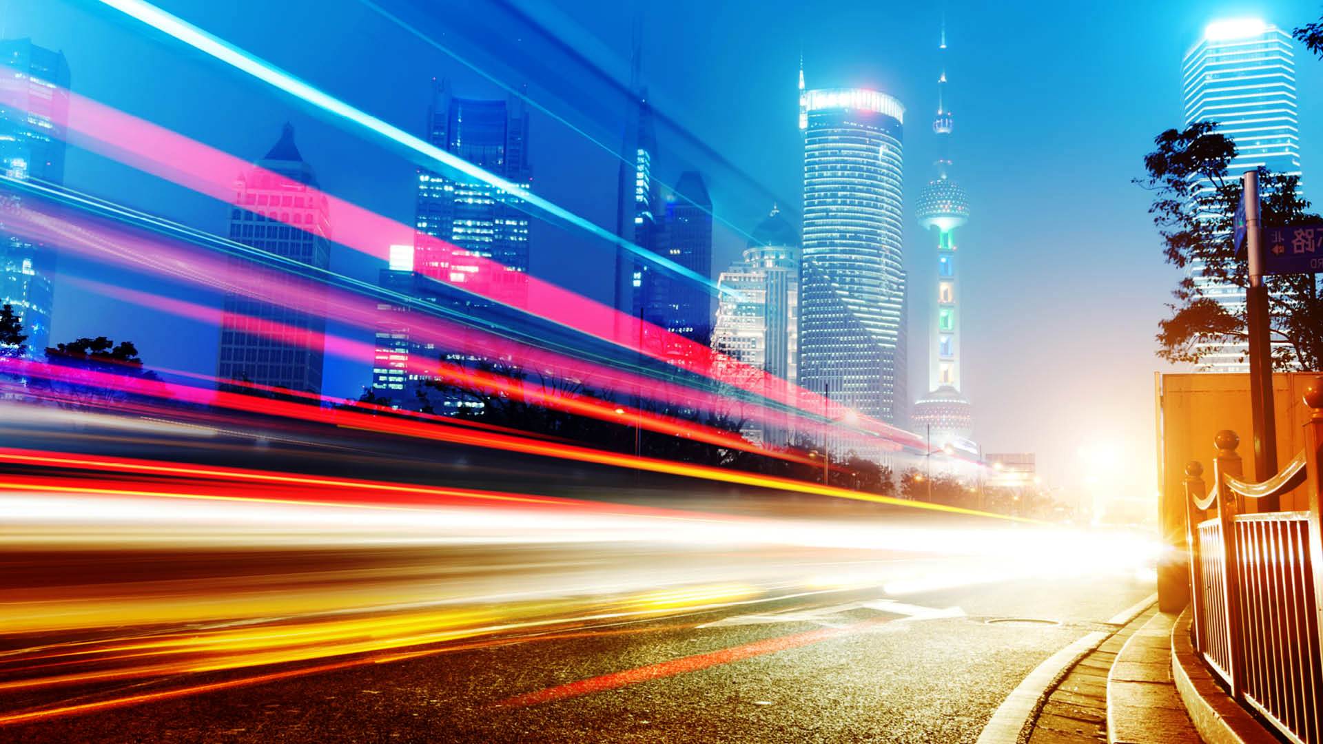 A global city in motion at night with luminous transport trails